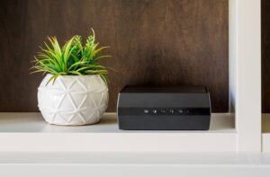 Router nero su mensola con pianta decorativa