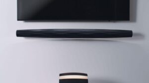 Soundbar nera montata sotto televisore nero.