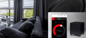 Sistema audio con smartphone e subwoofer in salotto moderno.