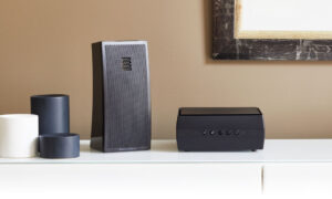 Casse audio e amplificatore su mobile bianco.